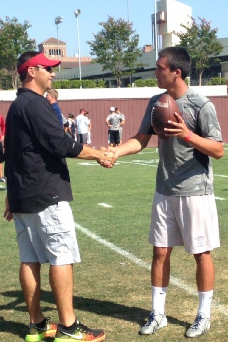 アメフト選手としてUSCのキャンプに参加し、当時のコーチと握手をするヌートバー（母・久美子さん提供）