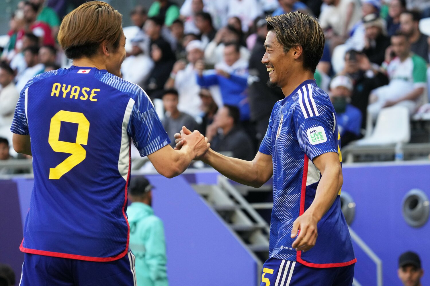 イラン戦で先制ゴール後に上田綺世と握手して喜ぶ守田　©Getty Images