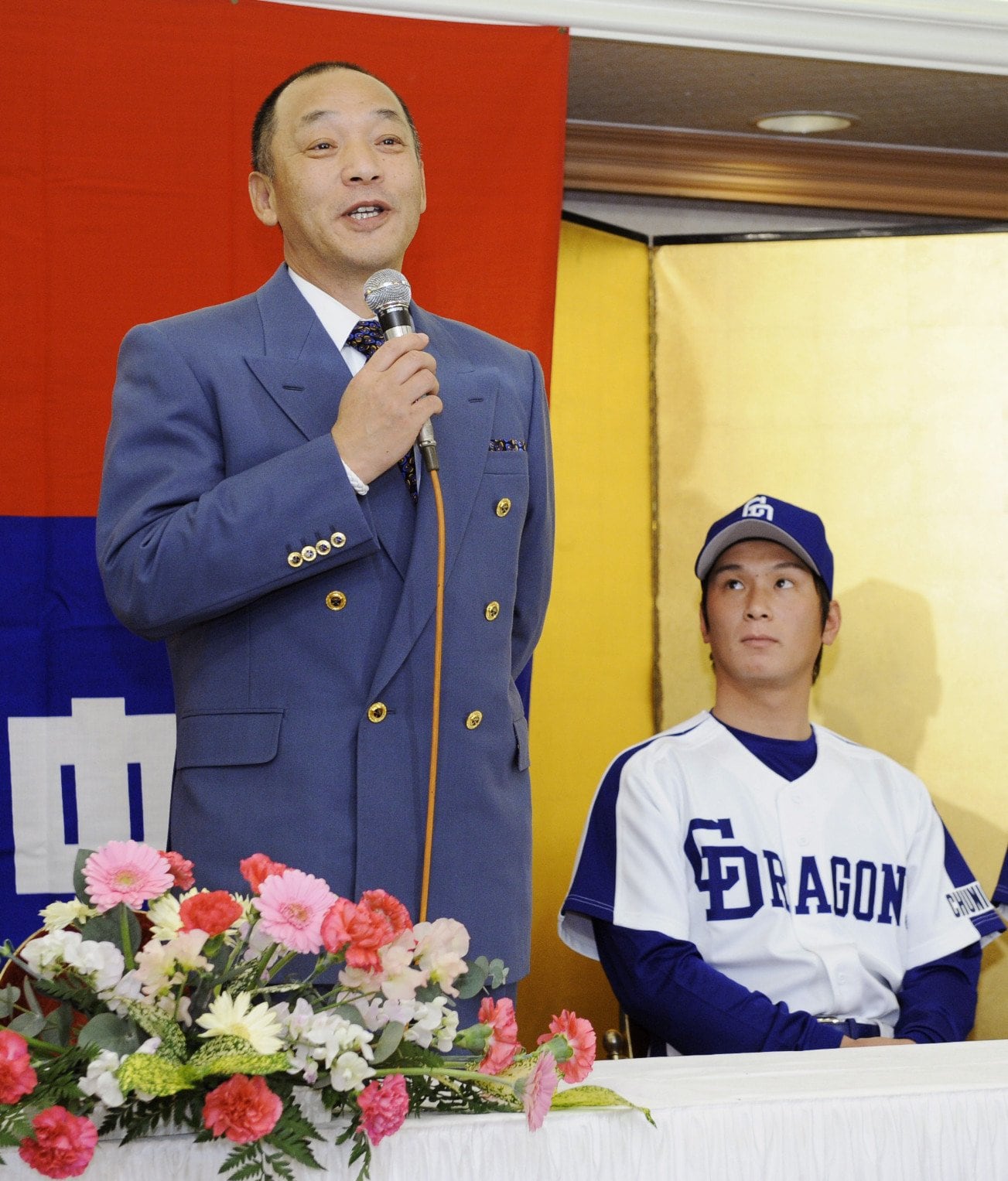 写真は2008年12月、中日の新入団発表。新人選手への期待を語る落合監督。右がドラフト1位指名された野本圭　©KYODO