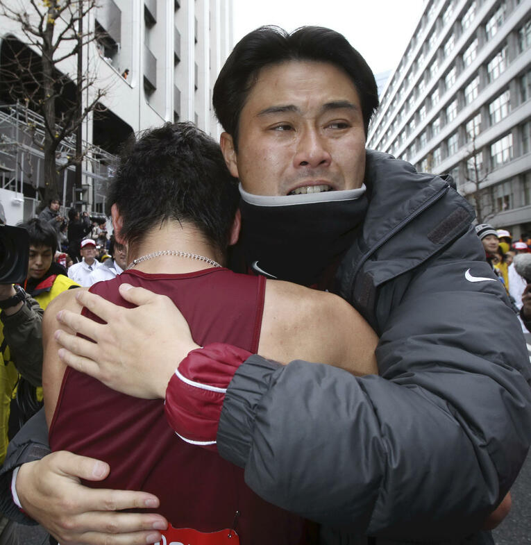 悲願の箱根駅伝優勝後、涙を流して選手と抱擁する渡辺康幸監督　©JIJI PRESS