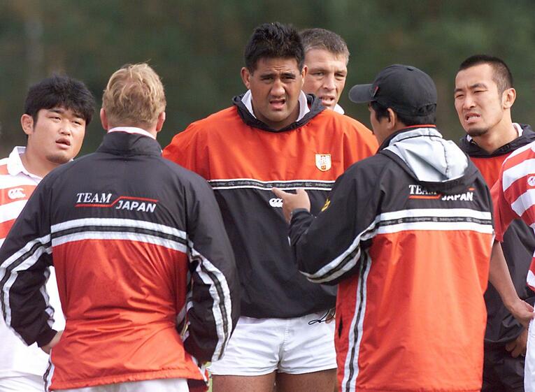 平尾誠二監督（手前）の話に耳を傾けるジェイミー・ジョセフ。左には若き日の長谷川慎コーチの姿も（1999年W杯）©︎AFP/AFLO