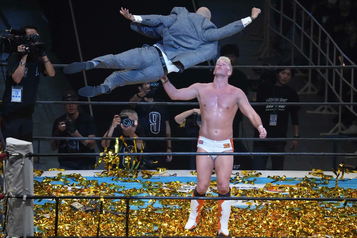 スーツ姿でザック・セイバーJr.に飛び掛かるリコシェ　©Essei Hara