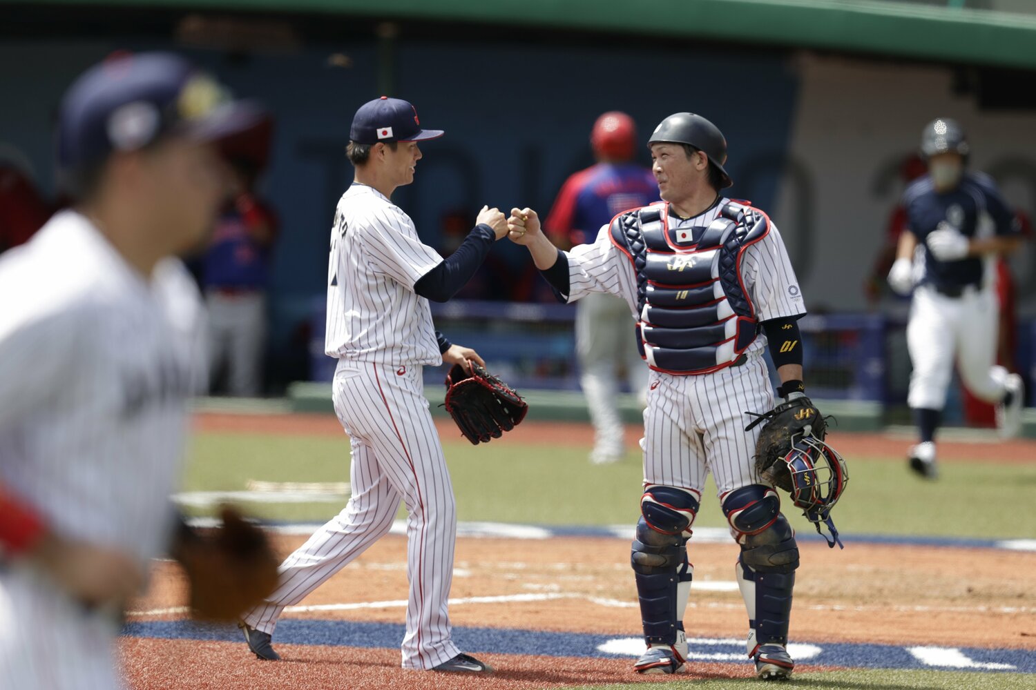 キャッチャー甲斐拓也にグータッチで迎えられる山本由伸　©︎Yuichiro Izawa/JMPA