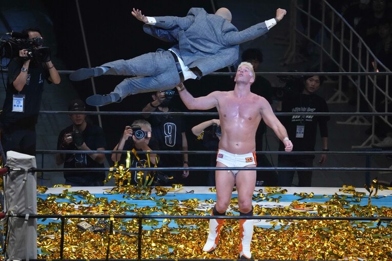 スーツ姿でザック・セイバーJr.に飛び掛かるリコシェ　©Essei Hara