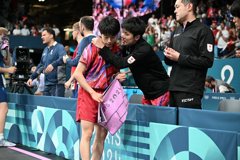 男子卓球団体戦3位決定戦、最終戦を託された篠塚に声をかける張本　©︎Naoya Sanuki/JMPA