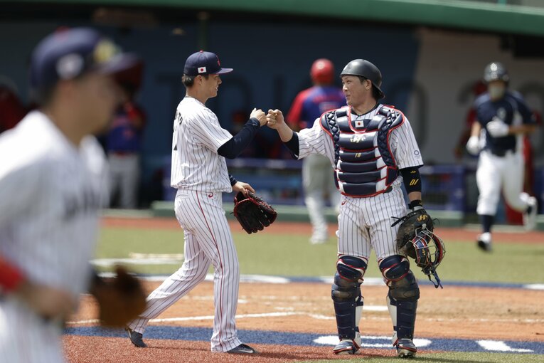キャッチャー甲斐拓也にグータッチで迎えられる山本由伸　©︎Yuichiro Izawa/JMPA