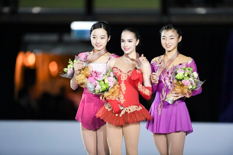 ジュニア時代のザギトワ。本田真凜（左）、坂本花織（右）とともに表彰台に立つ　©BUNGEISHUNJU