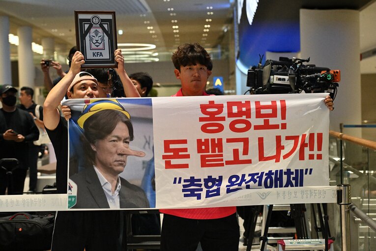 「ホン・ミョンボ！　カネを返して出ていけ！」仁川国際空港でプラカードを掲げる韓国サポーター　©JIJI PRESS