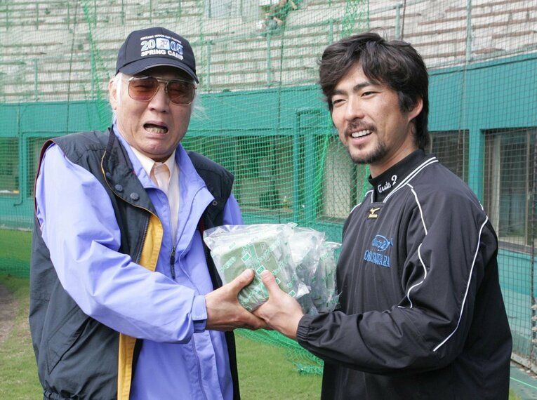 2005年2月、日本ハムに在籍していた小笠原道大に青汁を差し入れる球団OB・八名信夫 ©Sankei Shimbun