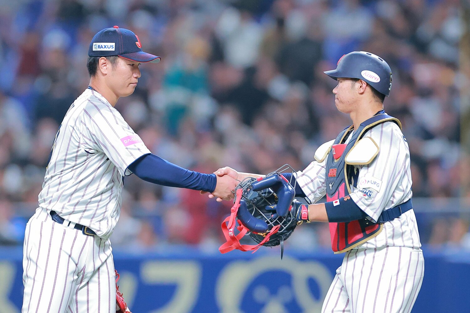 三者連続三振で試合をしめて握手を交わしたクローザーの清水達也と捕手の板倉将吾　©︎SANKEI SHIMBUN