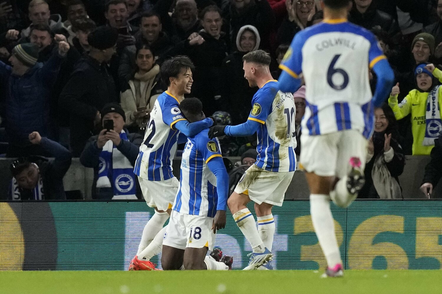 リバプール戦、3ゴール目を挙げたFWウェルベックを笑顔で祝福する三笘　©AFLO