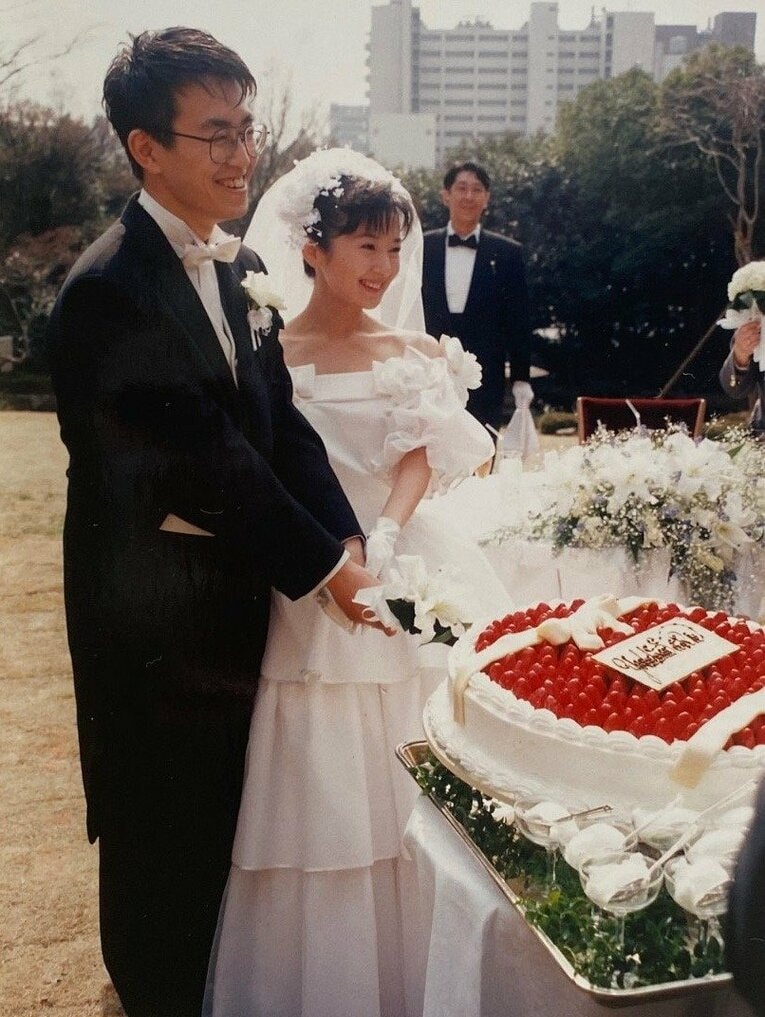 庭園でウェディングケーキを切る新郎新婦（2枚中の2枚目）　©Noboru Tamaru