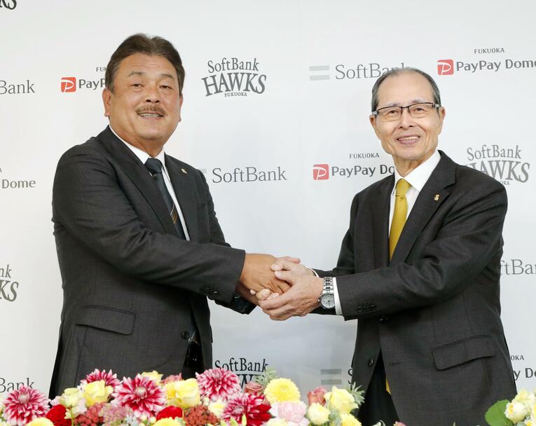 就任が決まり、王会長と握手 ©Kyodo News