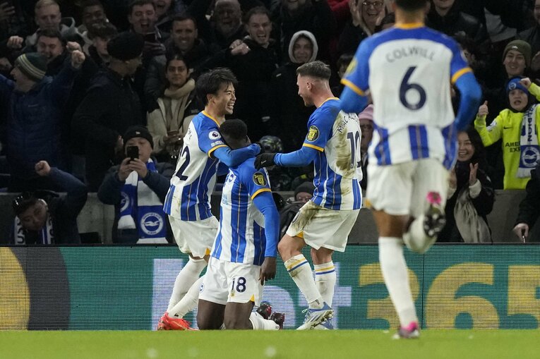 リバプール戦、3ゴール目を挙げたFWウェルベックを笑顔で祝福する三笘　©AFLO