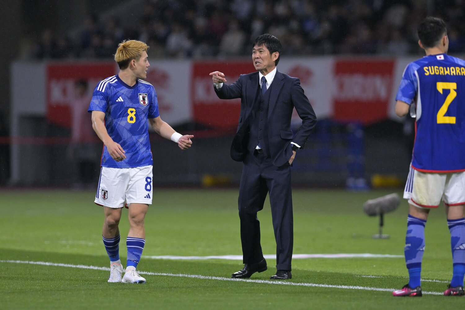 ピッチサイドで監督とやりとりする堂安 ©Koki Nagahama／JMPA