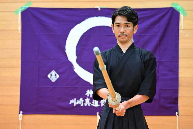 道場旗の前で　©Keiji Ishikawa