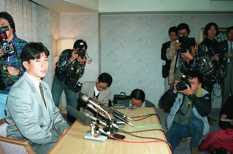 野茂英雄のメジャー挑戦発表会見。異例の「球団旗なし」「イスなし」の光景が広がっていた（スクロールすると通常の球団旗ありの記者会見写真をご覧になれます）　©JIJI PRESS