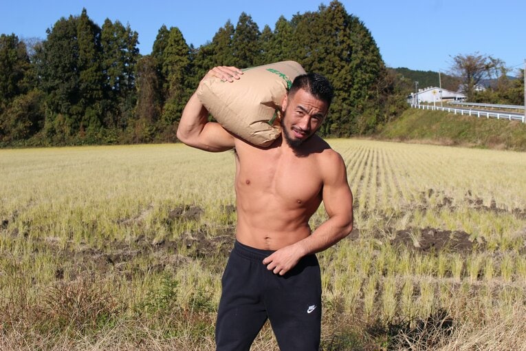 自慢の米を担いでポーズ決める手塚裕之（2枚目／全4枚）©Number Web