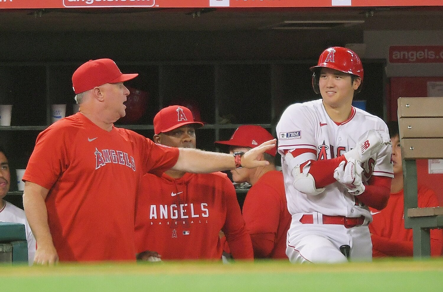 ベンチで言葉を交わすネビン監督(左)と大谷 ©︎JIJI PRESS