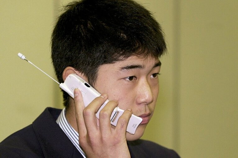 2000年11月17日、ドラフト会議でオリックスから1位指名を受けた敦賀気比高時代の内海哲也。携帯電話で仰木彬監督と言葉を交わした ／ photograph by JIJI PRESS