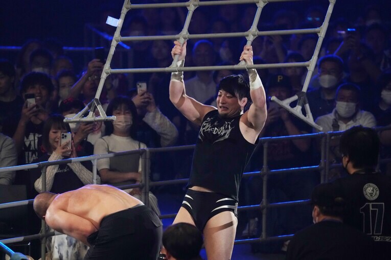 客席のガードレールをジョン・モクスリーに叩きつける成田蓮　©Essei Hara