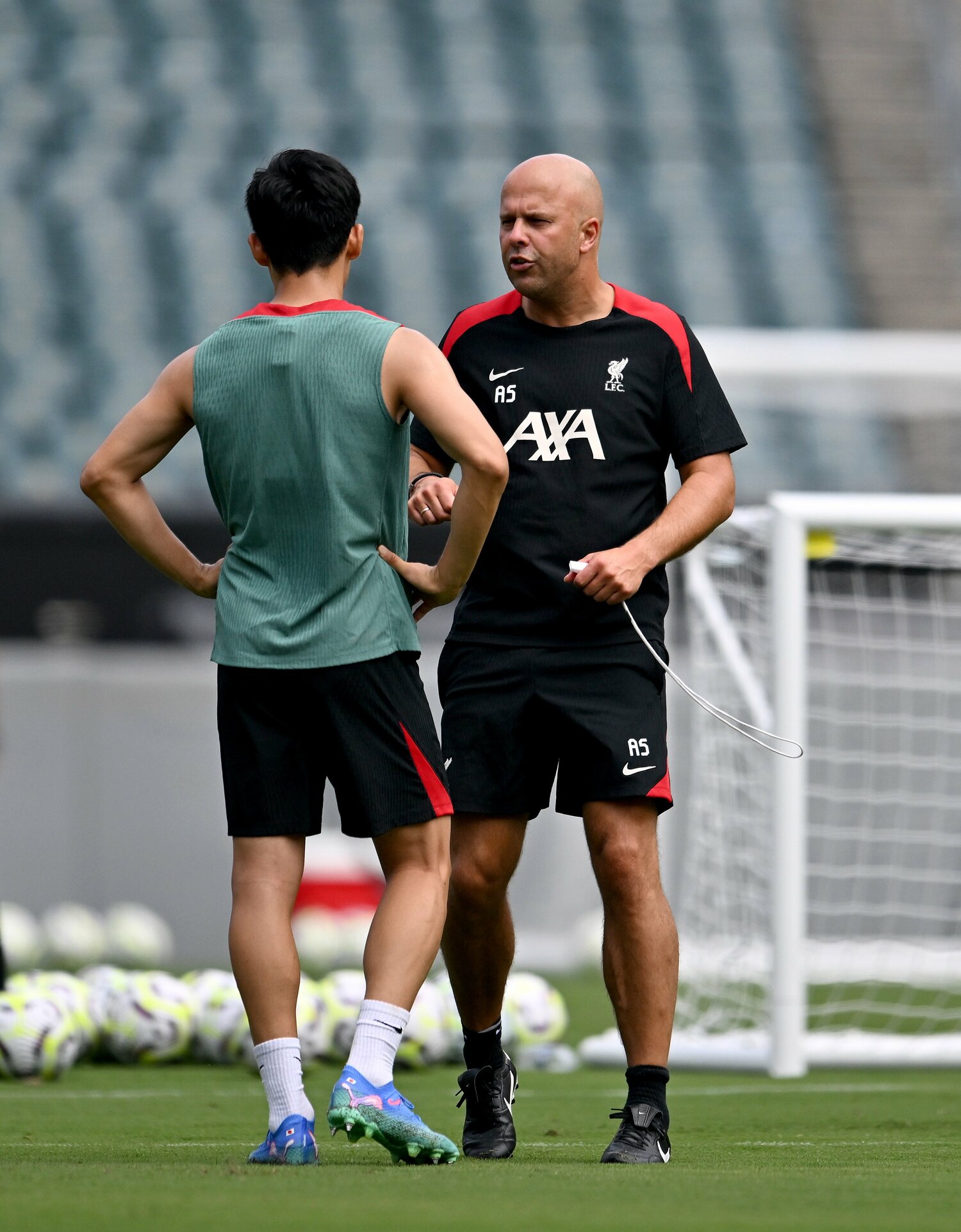 プレシーズンのトレーニングでリバプール新監督のスロットと話す遠藤 ©︎Getty Images