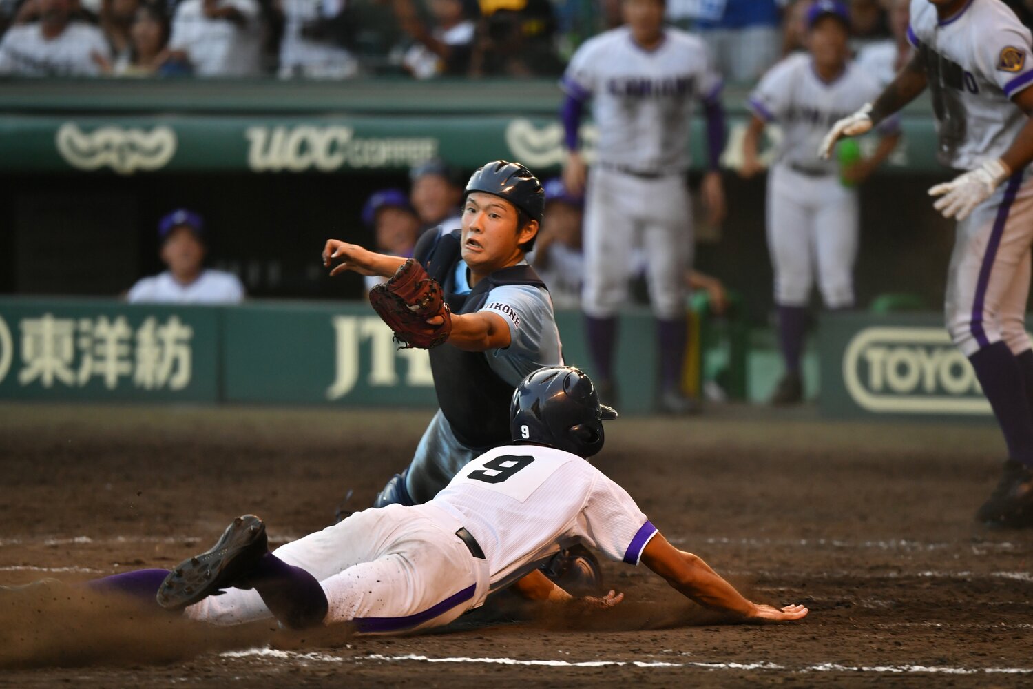 有馬諒のタッチをかいくぐり、本塁に突入する二塁走者の菊地彪吾　©Hideki Sugiyama