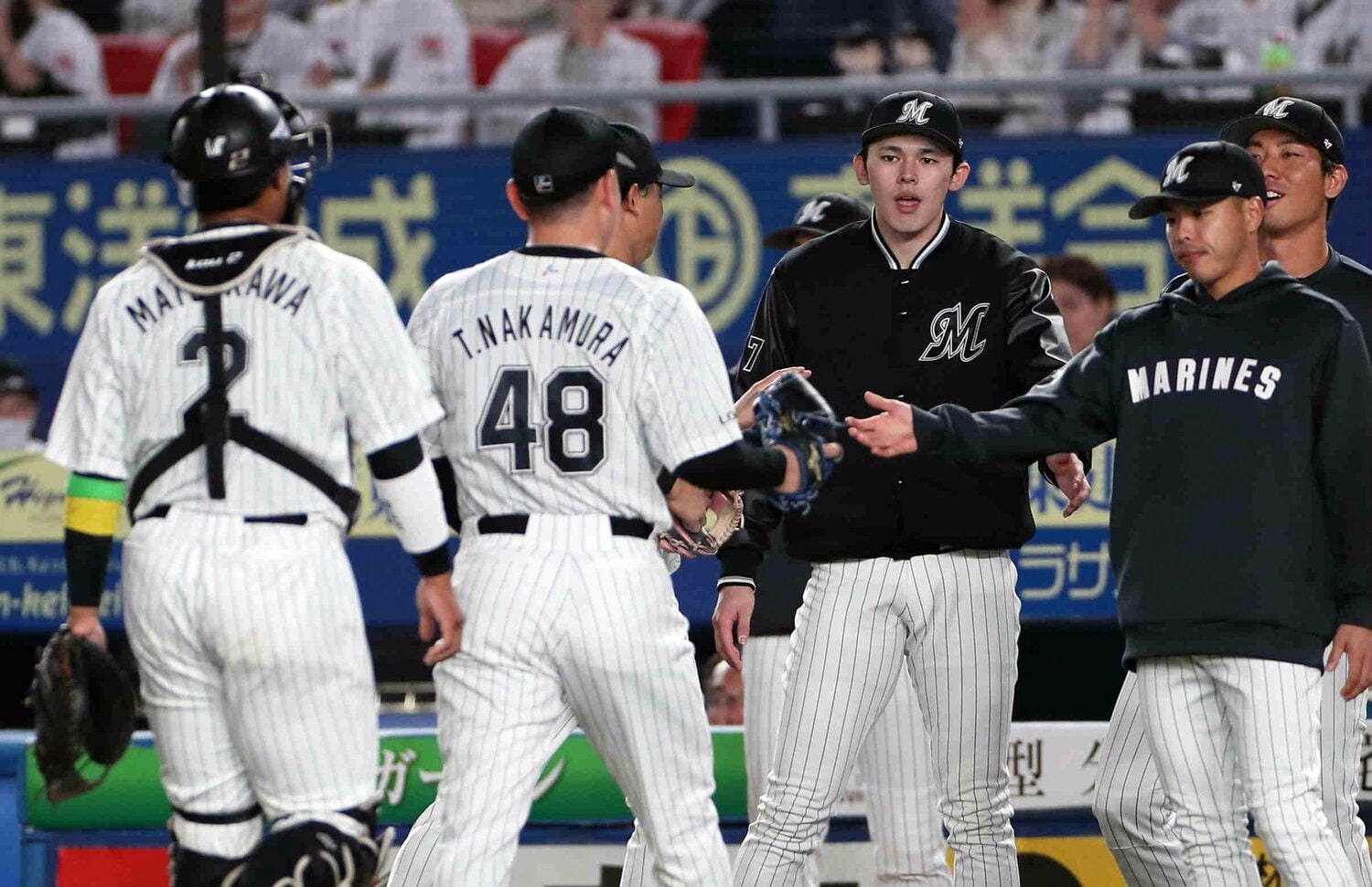 ４回を無失点に抑えた（左から）松川と２番手の中村稔弥をベンチ前で迎える先発の佐々木朗希（中央右）　©JIJI PRESS