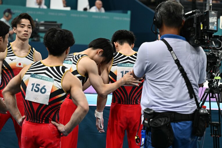 鉄棒の演技直前、萱に背中を叩かれる橋本　©Naoya Sanuki/JMPA