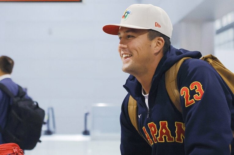 準決勝に向け、アメリカの空港に到着したヌートバー。疲れのたまる中、報道陣の前ではこの笑顔 ／ photograph by JIJI PRESS