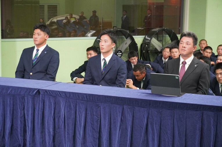 10月23日、仙台育英高校。ドラフト会議のテレビ中継を見つめる須江航監督。プロ野球志望届を提出していた3年生の高田庵冬（左）と吉川陽大（中央）。後ろでは野球部員が祈るように手を合わせる　©Kei Nakamura