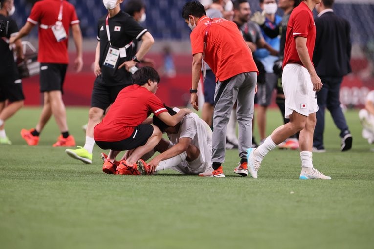 涙に暮れる久保建英にも声をかけるなど、選手たちの健闘を称えた西村コーチ　©︎Kaoru Watanabe/JMPA