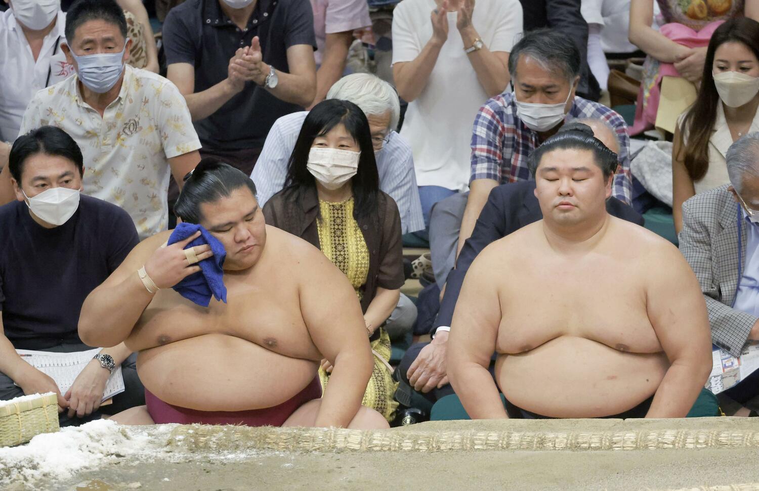 千秋楽で若元春に敗れ、土俵下でさえない表情の大関・御嶽海。右は大関・正代、どちらも4勝11敗と苦しんだ　©KYODO