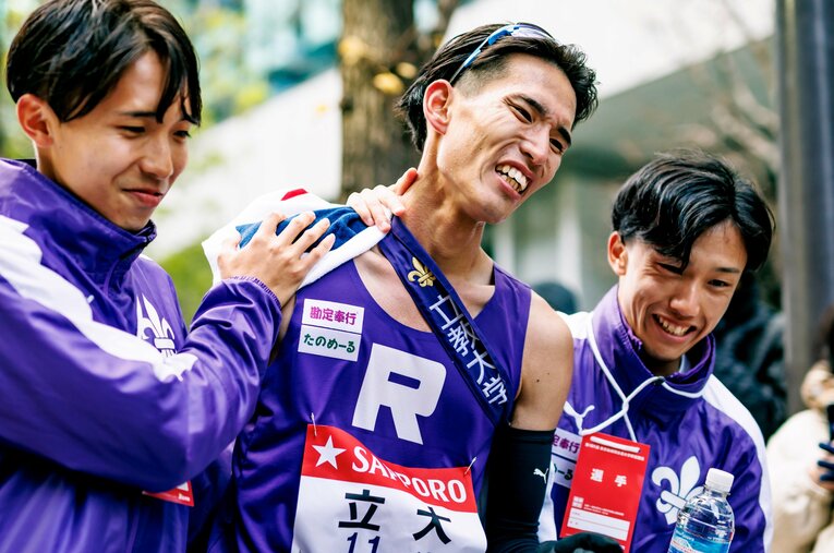 シード権争い集団から脱落して無念の表情でゴールした立教大10区・永井駿を迎えるチームメイト ／ photograph by Kiichi Matsumoto