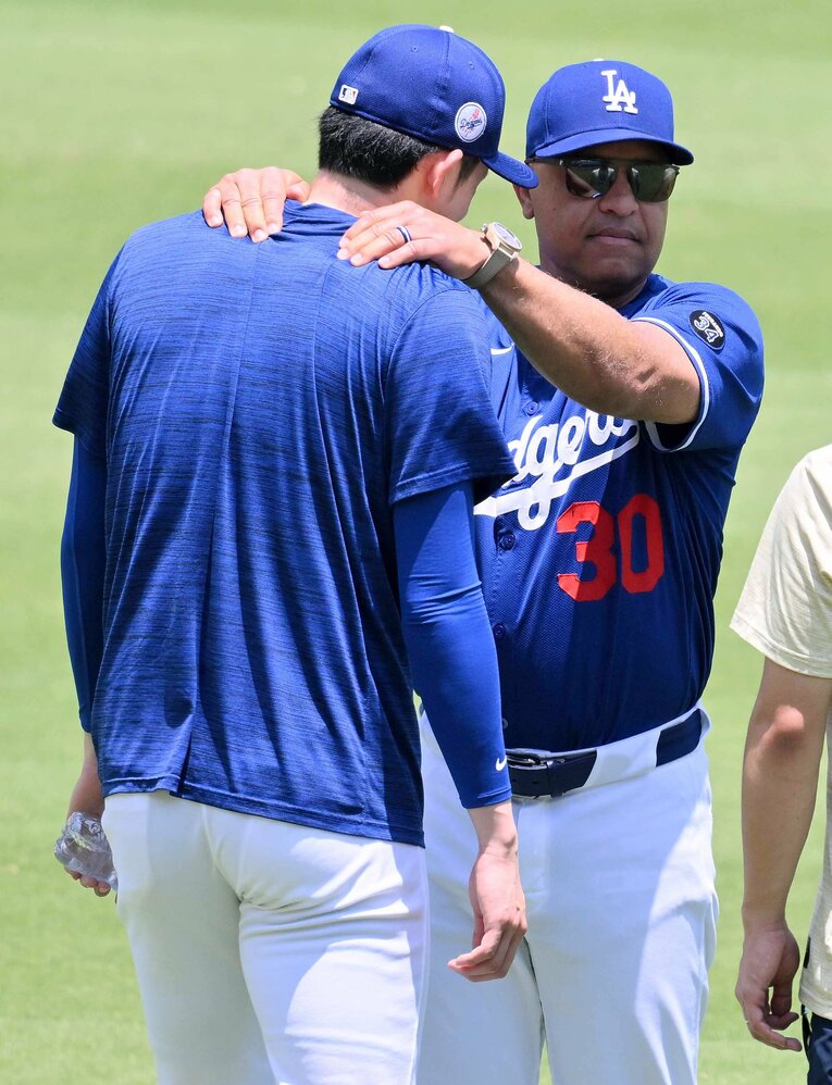 トレーニングで朗希の肩をモミモミ　©JIJI PRESS