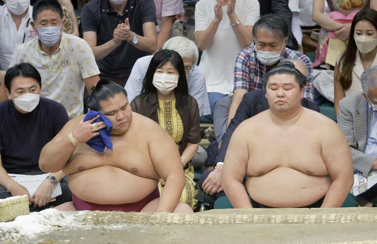 千秋楽で若元春に敗れ、土俵下でさえない表情の大関・御嶽海。右は大関・正代、どちらも4勝11敗と苦しんだ　©KYODO