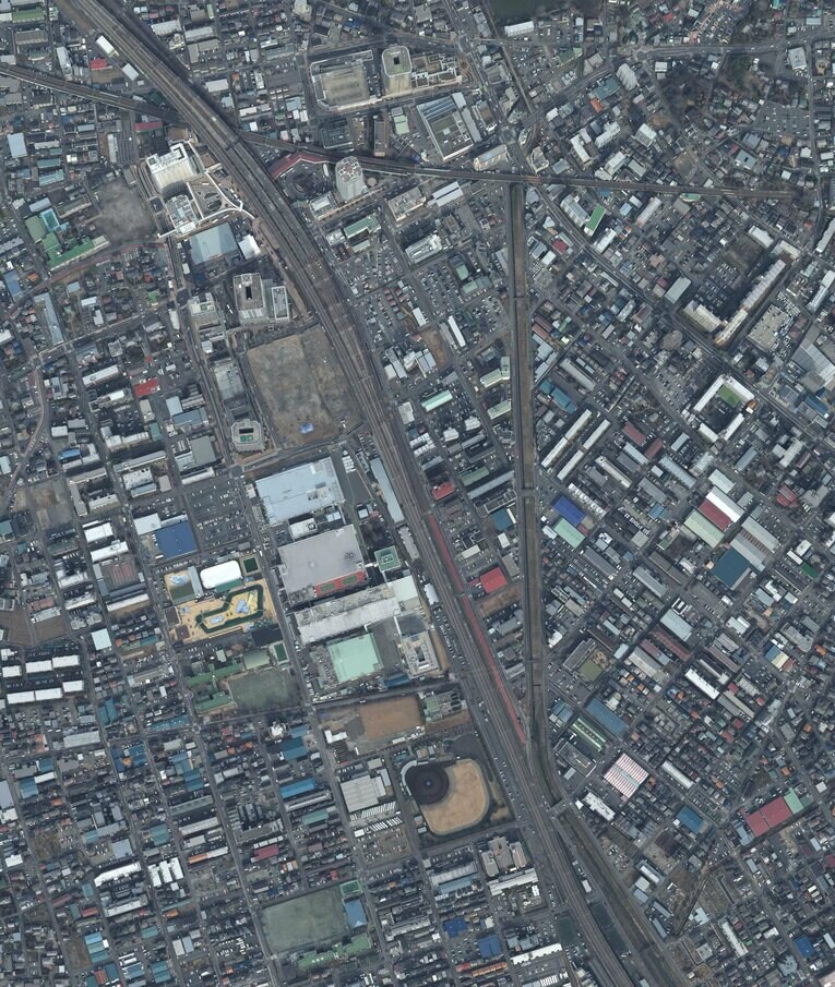 2013年に撮影された武蔵浦和付近の航空写真。中央左、大きな四角が並ぶロッテ浦和工場。その下にロッテ浦和球場があるのが分かる。その右を走るのが東北新幹線・埼京線　出典：国土地理院の空中写真