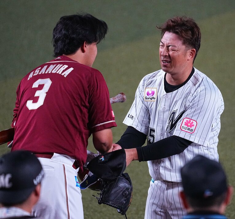 引退登板で右肘を痛め、苦痛に顔を歪めながらも打者の浅村と握手を交わす　©SANKEI SHIMBUN