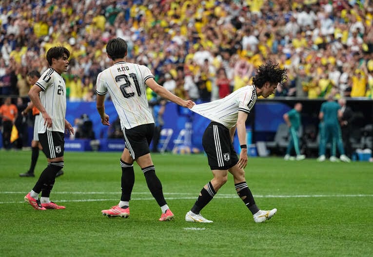 失点直後、田中のユニフォームを引っ張って起こす伊藤　©Getty Images