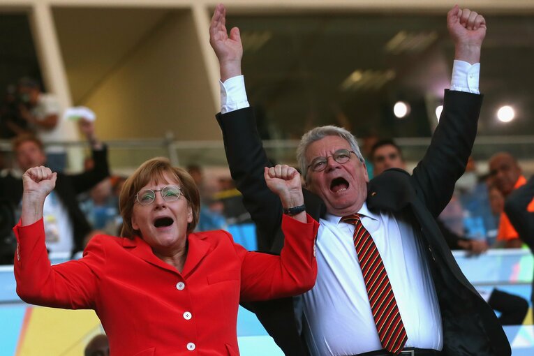 ドイツ代表のゴールに思わず立ち上がるメルケル元首相（左、2014年）©︎Getty Images