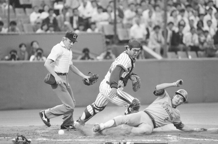 鋭いスライディングでホームに突入する高橋慶彦。キャッチャーは八重樫幸雄　©JIJI PRESS