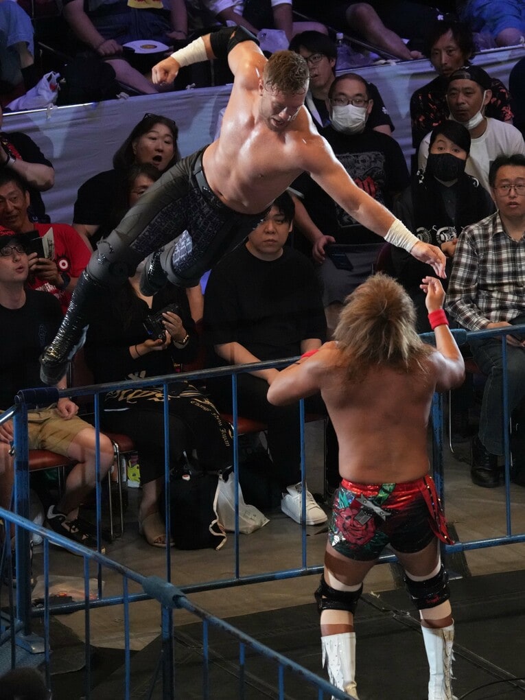 鉄柵から内藤哲也にエルボーを放つウィル・オスプレイ。8月12日、両国国技館