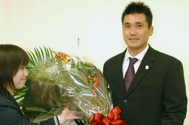 記者会見で引退を発表後、花束を贈られる黒木知宏投手 ／ photograph by KYODO