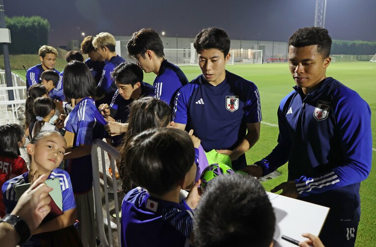 現地カタール在住の子どもたちにサインする藤田、細谷ら　©JIJI PRESS