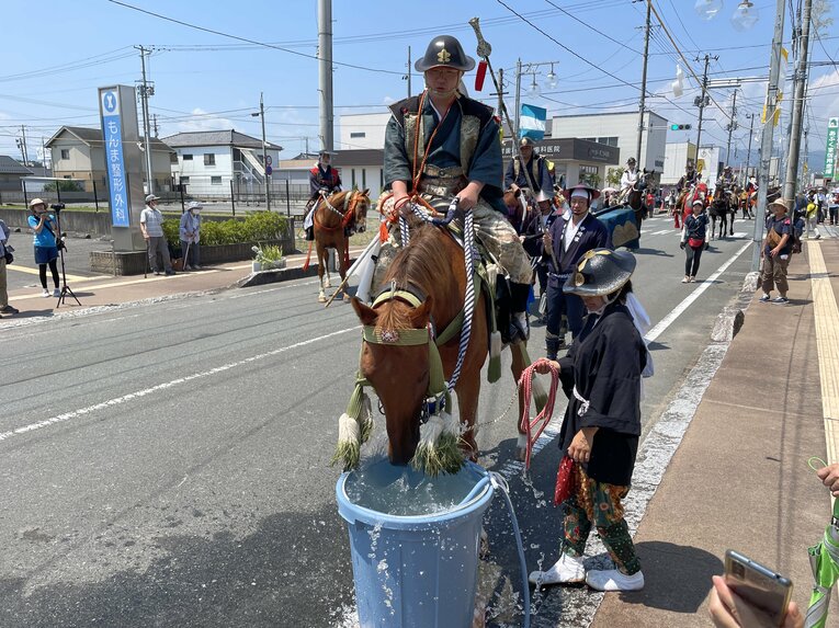 宵乗り行列の道中で水分補給をする馬たち