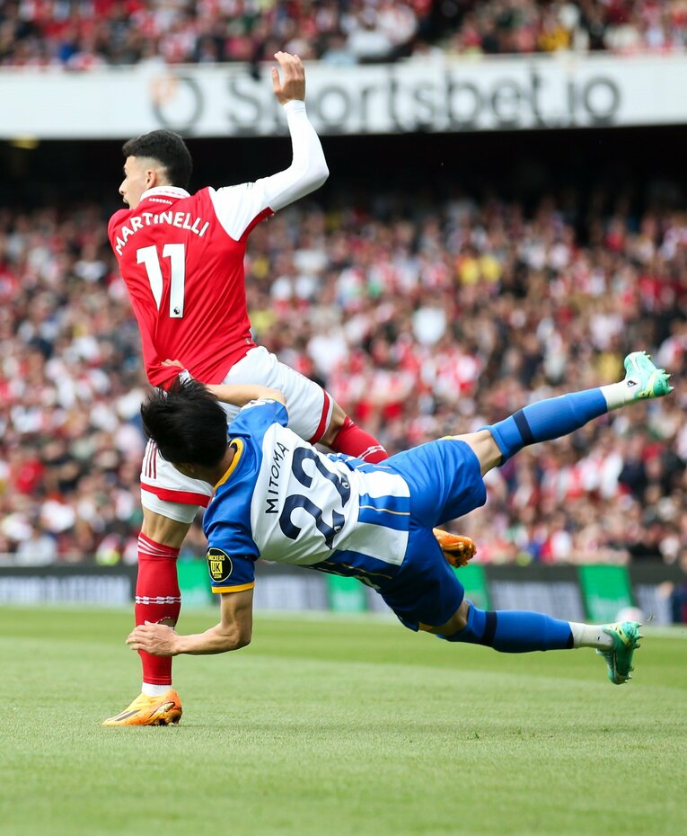 アーセナル戦、前半5分。ルーズボールを競り合う場面。死角から入ってきたマルティネッリの“危険なチャージ”を受けた三笘。しばらくピッチ上で動けない時間が続いた　©AFLO