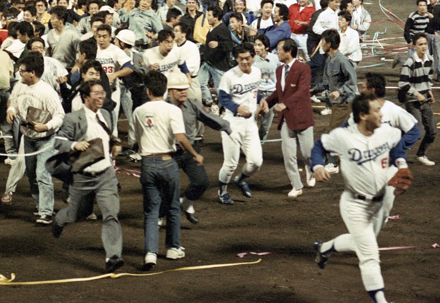 1988年10月7日、中日がセ・リーグ優勝。グラウンドに乱入したファンから逃げるようにベンチへ戻る落合博満（右下）　©Sankei Shimbun