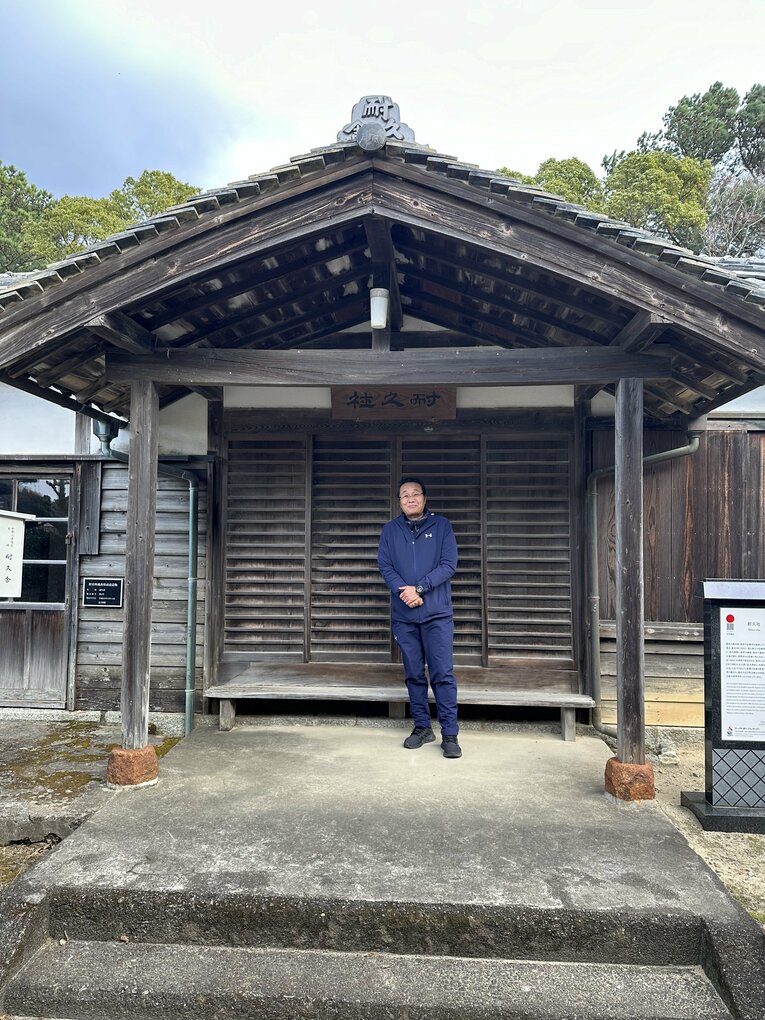 28年間にわたって母校でもある耐久で教鞭を執る白井敏之教諭と、耐久中学校に現存する耐久社　©Yuji Yanagawa