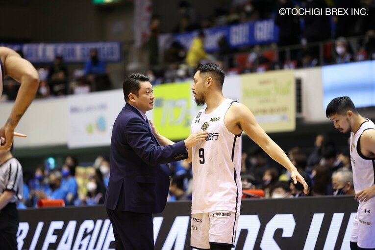 遠藤祐亮の胸を叩く安齋HC