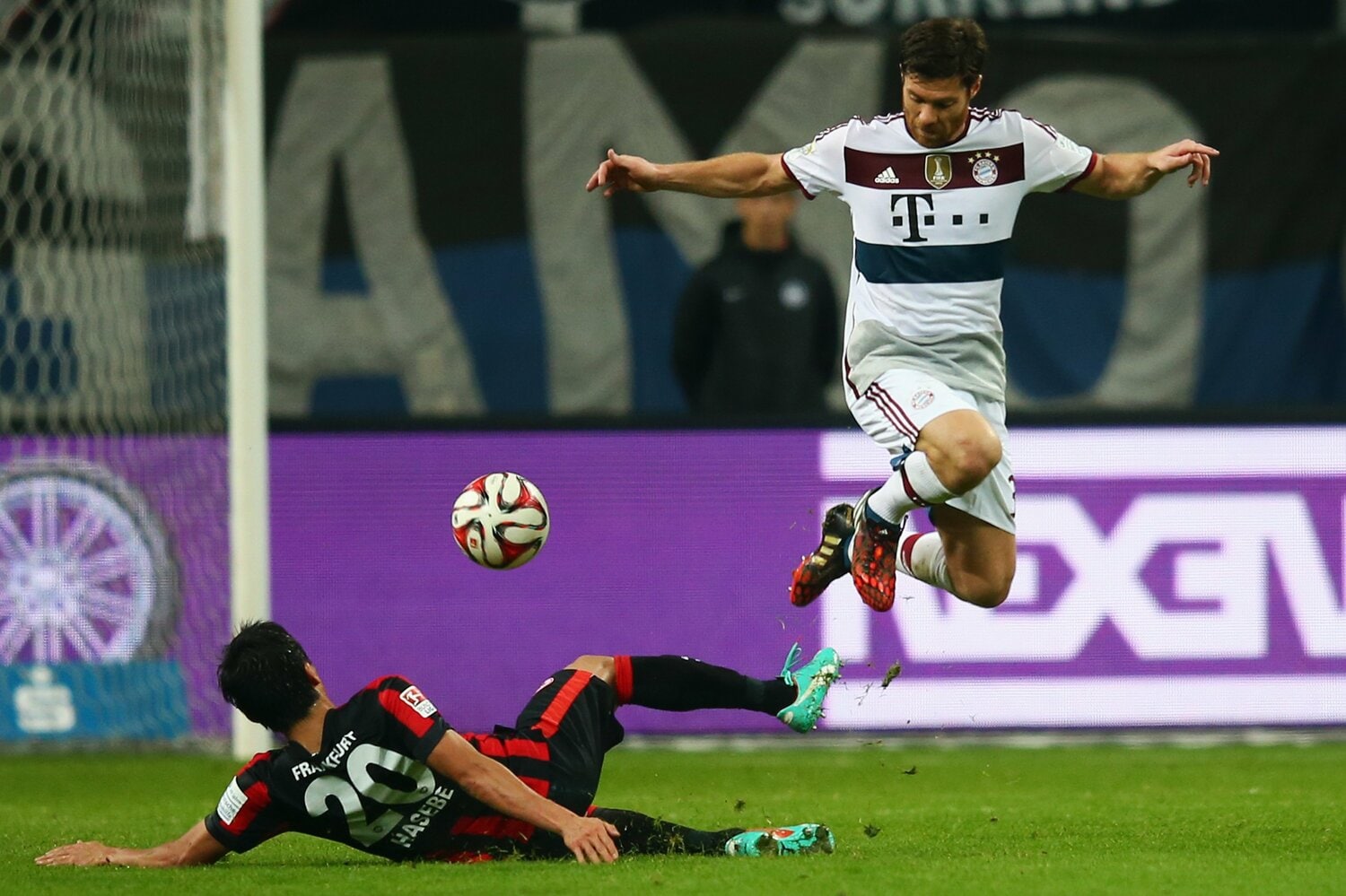 2014年、シャビ・アロンソにスライディングタックルを仕掛ける長谷部　©Getty Images